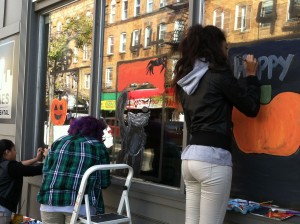 Students painting business windows for halloween in jersey city heights
